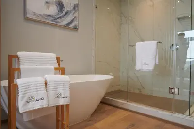 a bathroom with a bath tub and a glass shower at When Away - Your Home Away from Home in Pretoria