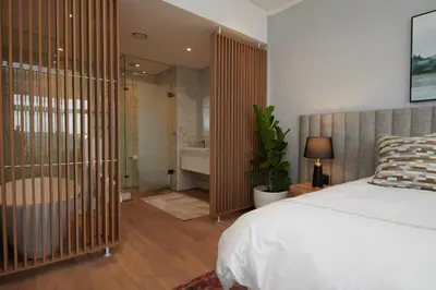 a bedroom with a bed and a bathroom with a tub at When Away - Your Home Away from Home in Pretoria