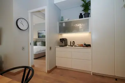 a kitchen with white cabinets and a clock on a wall at When Away - Your Home Away from Home in Pretoria