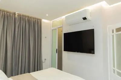 a bedroom with a bed and a tv on a wall at Hatfield on Park B in Pretoria