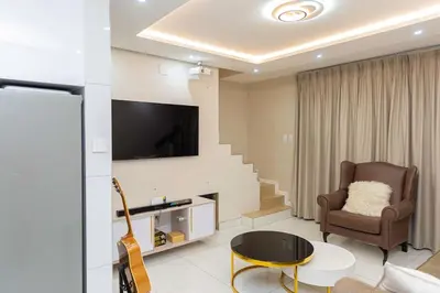 a living room with a chair and a television at Hatfield on Park B in Pretoria
