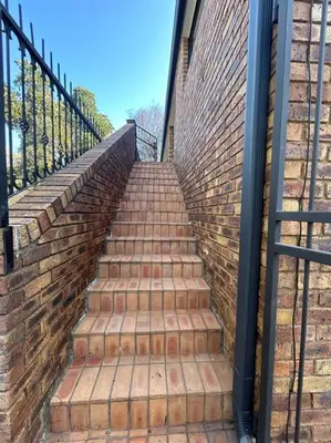 a set of stairs leading up to a brick wall at Galaxy Retreat in Pretoria