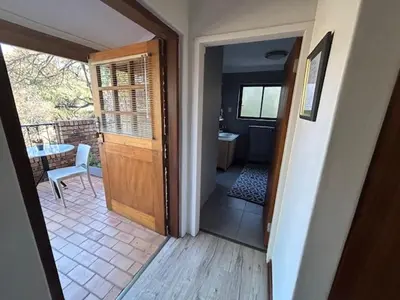 a room with a door leading to a balcony with a table at Galaxy Retreat in Pretoria