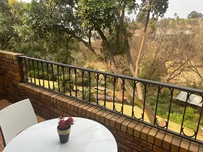 a table with a vase of flowers on a balcony at Galaxy Retreat in Pretoria