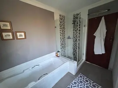 a large bathroom with a tub and a shower at Galaxy Retreat in Pretoria