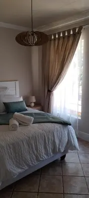 a bedroom with a bed and a window at Pearlman Loft in Tzaneen