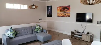 a living room with a couch and a flat screen tv at Pearlman Loft in Tzaneen