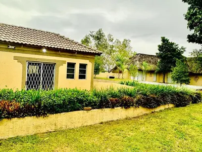 a house with a row of bushes in front of a yard at Soaring Summit Lodge in Ronaldsey