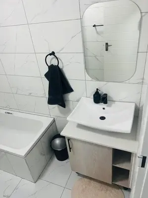 a white bathroom with a sink and a mirror at KT Comfort in Midrand