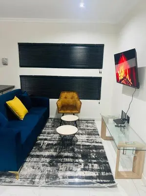 a living room with a blue couch and a table at KT Comfort in Midrand
