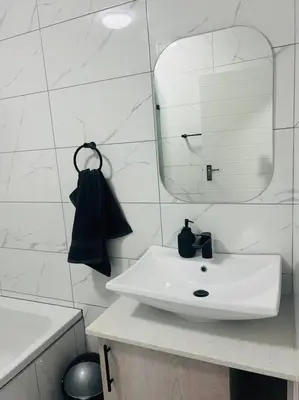 a white bathroom with a sink and a mirror at KT Comfort in Midrand