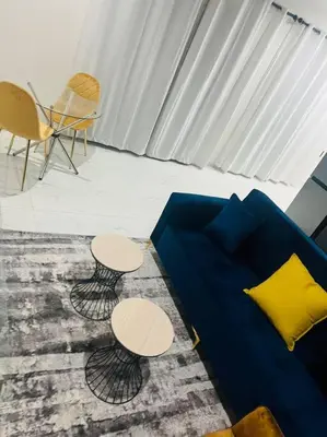 a living room with a blue couch and two tables at KT Comfort in Midrand