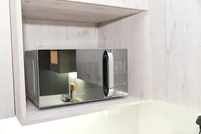 a microwave hanging on a wall in a kitchen at Eirini Elegant - Hermes Apartment in Midrand