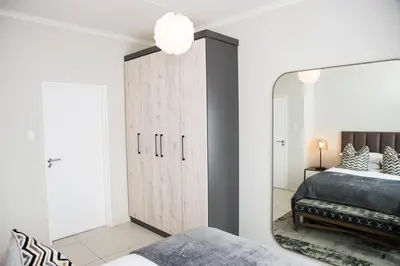 a bedroom with a large mirror and a bed at Eirini Elegant - Hermes Apartment in Midrand