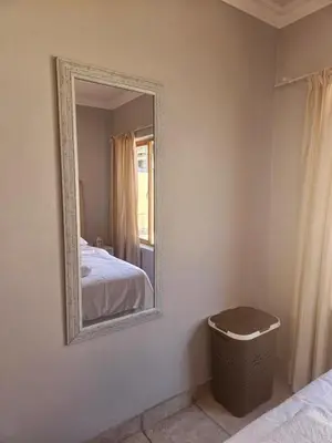 a mirror in a room with a bed and a trash can at Feel at Home in Monavoni