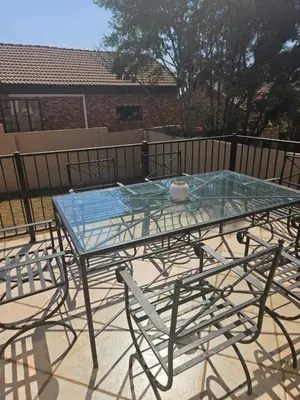 a glass table with chairs around it on a patio at Feel at Home in Monavoni