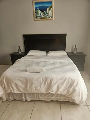 a large bed with white sheets and pillows on it at Feel at Home in Monavoni