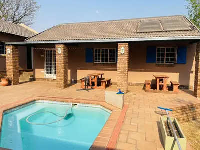 a swimming pool in front of a house at Melodie Guest House in Lone Star Texas