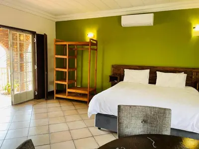 a bedroom with a bed and a green wall at Melodie Guest House in Lone Star Texas