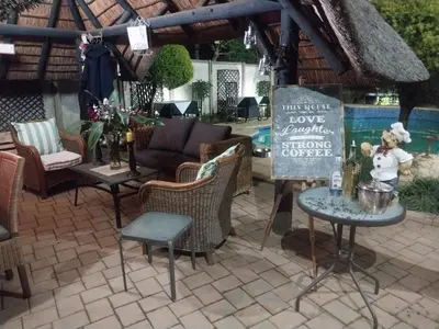 a patio with a table and chairs and a sign at The Zebra Suite at Frederick's Place in Pretoria