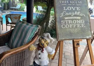 a teddy bear sitting in a chair next to a sign at The Zebra Suite at Frederick's Place in Pretoria