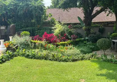 a garden with a bunch of flowers in a yard at The Zebra Suite at Frederick's Place in Pretoria