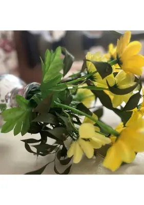a bunch of yellow flowers in a vase on a table at The Zebra Suite at Frederick's Place in Pretoria