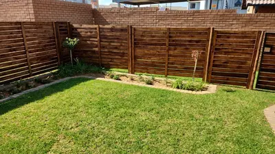 a wooden fence in a yard with grass at Moon Octave in Midrand