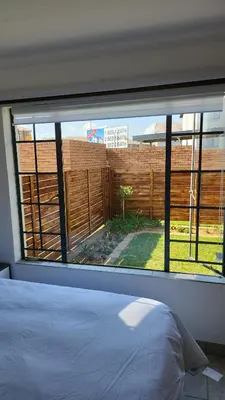 a bedroom with a window looking out at a fence at Moon Octave in Midrand