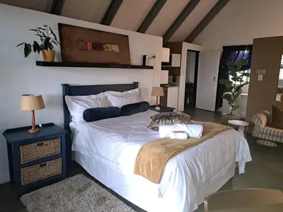 a bedroom with a large bed with white sheets at Casa Mana Air B&B in Pretoria