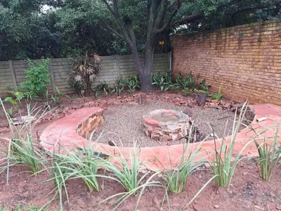 a garden with a tree and a brick wall at Casa Mana Air B&B in Pretoria