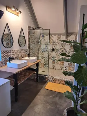a bathroom with two sinks and a wall with tiles at Casa Mana Air B&B in Pretoria