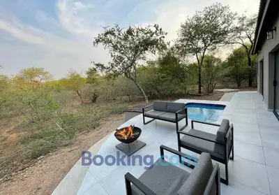 a patio with a fire pit and a swimming pool at Shomoro Rest in Marloth Park