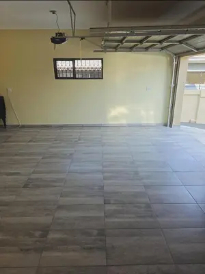 an empty room with a tile floor and a window at SammyGrace Holiday Home in Tzaneen