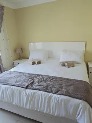 a large white bed with two pillows on it at SammyGrace Holiday Home in Tzaneen