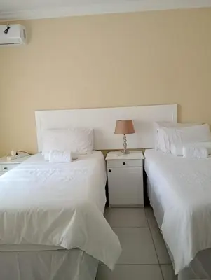 two beds sitting next to each other in a room at SammyGrace Holiday Home in Tzaneen