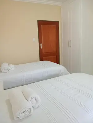 two beds in a room with towels on them at SammyGrace Holiday Home in Tzaneen