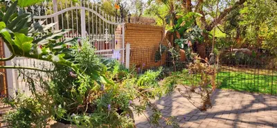 a garden with a white fence and some plants at Harmony Suite in Pretoria