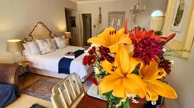 a bedroom with a bed and a vase of flowers at Harmony Suite in Pretoria