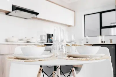 a white table with wine glasses and plates on it at The Blyde Crystal Villa Apartment in Pretoria