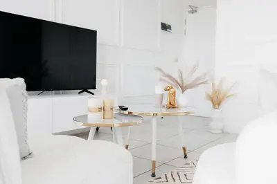 a living room with two tables and a tv at The Blyde Crystal Villa Apartment in Pretoria