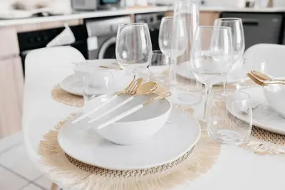 a table with white plates and wine glasses on it at The Blyde Crystal Villa Apartment in Pretoria