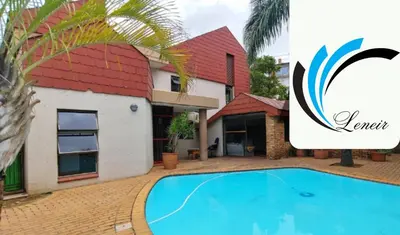 a villa with a swimming pool in front of a house at Leneir in Pretoria