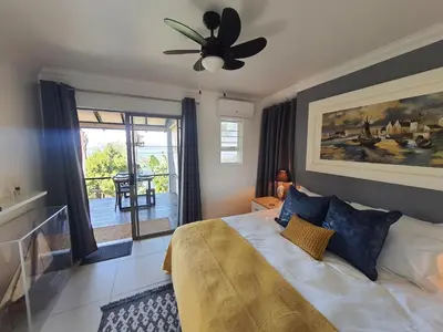 a bedroom with a bed and a ceiling fan at Fever Tree View in Hartbeespoort
