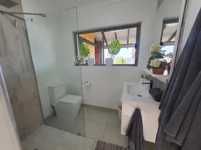 a bathroom with a shower and a toilet and a sink at Fever Tree View in Hartbeespoort