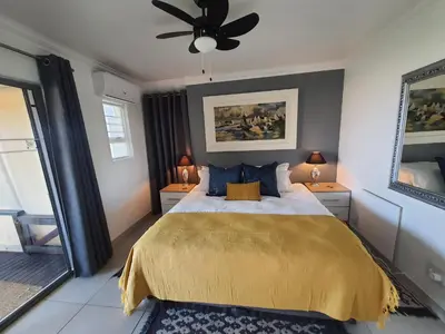 a bedroom with a bed and a ceiling fan at Fever Tree View in Hartbeespoort