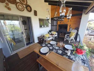 a dining room with a table and a fireplace at Fever Tree View in Hartbeespoort