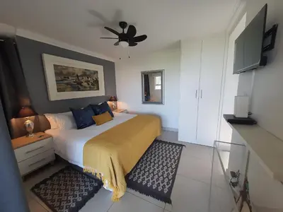 a bedroom with a bed and a ceiling fan at Fever Tree View in Hartbeespoort