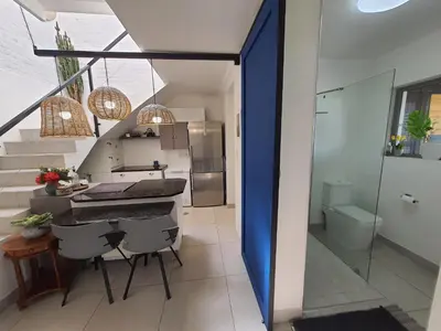 a kitchen and dining room with a blue wall at Fever Tree View in Hartbeespoort