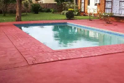 a swimming pool with a red floor and a red brick floor at Steenbok Guesthouse in Steenbok